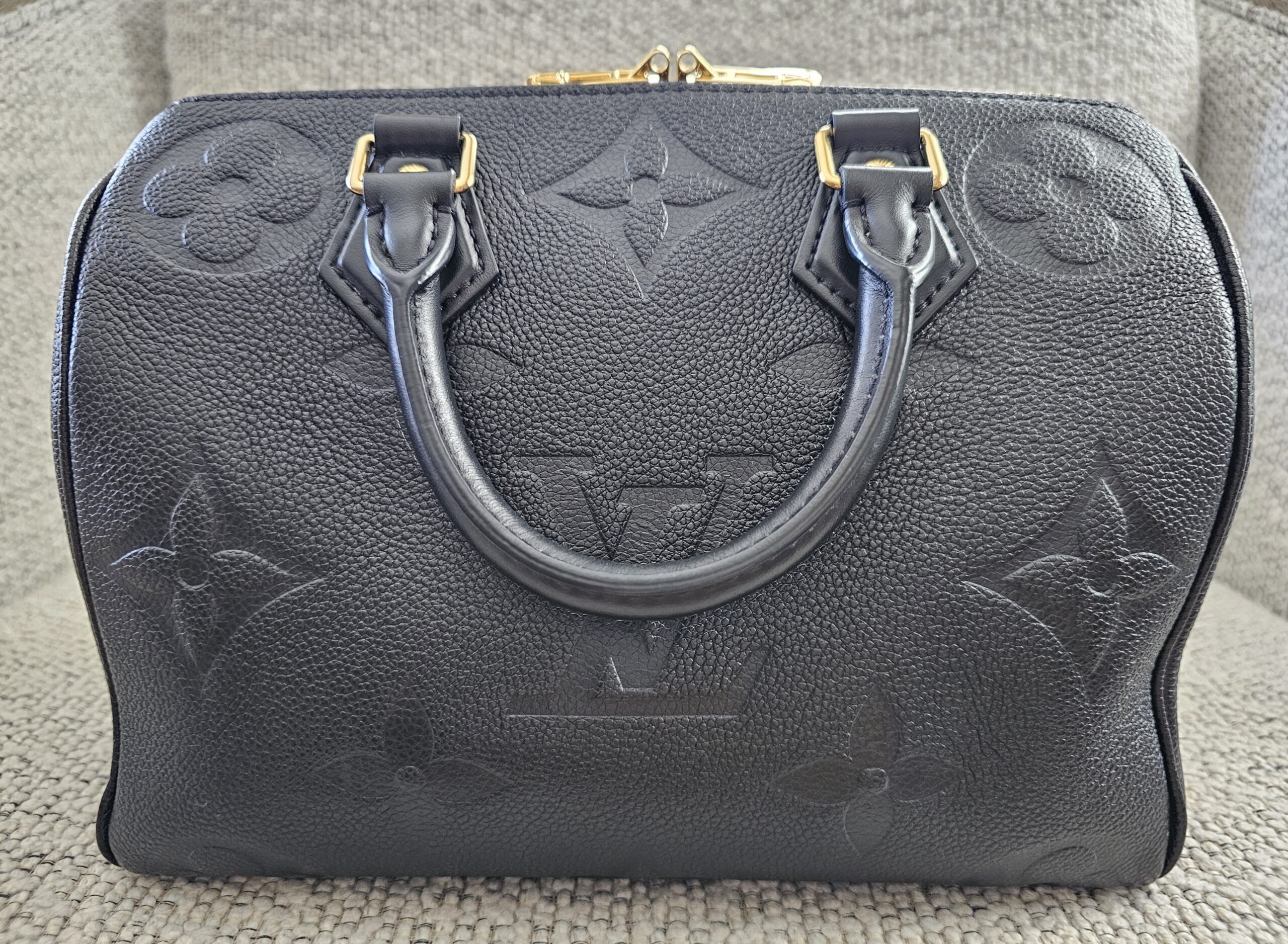 Oversized giant monogram embossing across the front panel of the black Empreinte Speedy Bandouliere 25