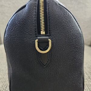 Side profile of the black Empreinte Speedy Bandouliere 25 with gold-tone D-ring