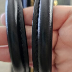 Rolled leather handles of the black Empreinte Speedy Bandouliere 25 held together to show wear