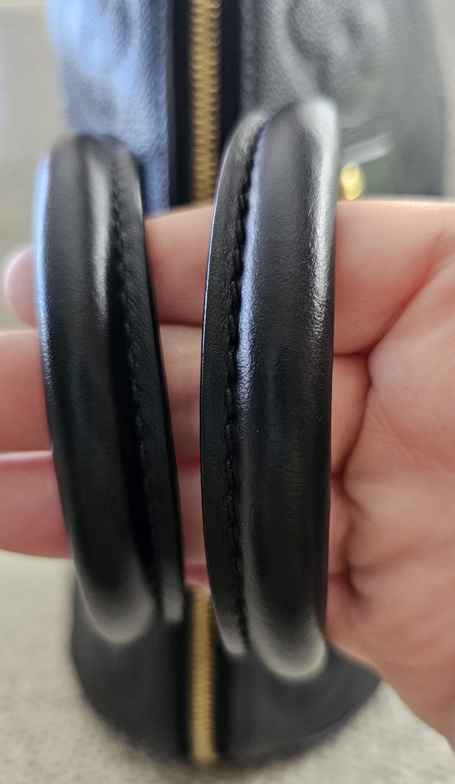 Rolled leather handles of the black Empreinte Speedy Bandouliere 25 held together to show wear
