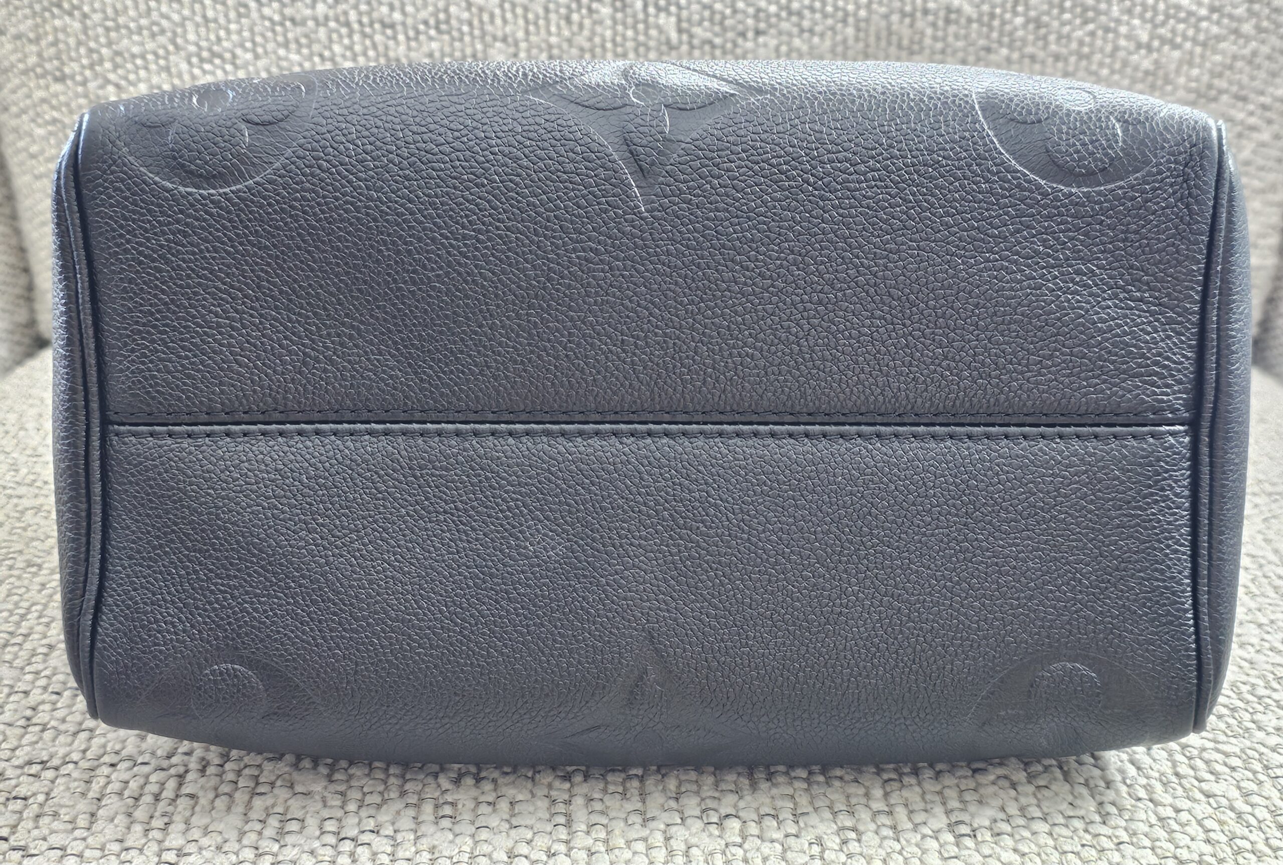 Base of the black Giant Monogram Empreinte Speedy Bandouliere 25 with embossed monogram