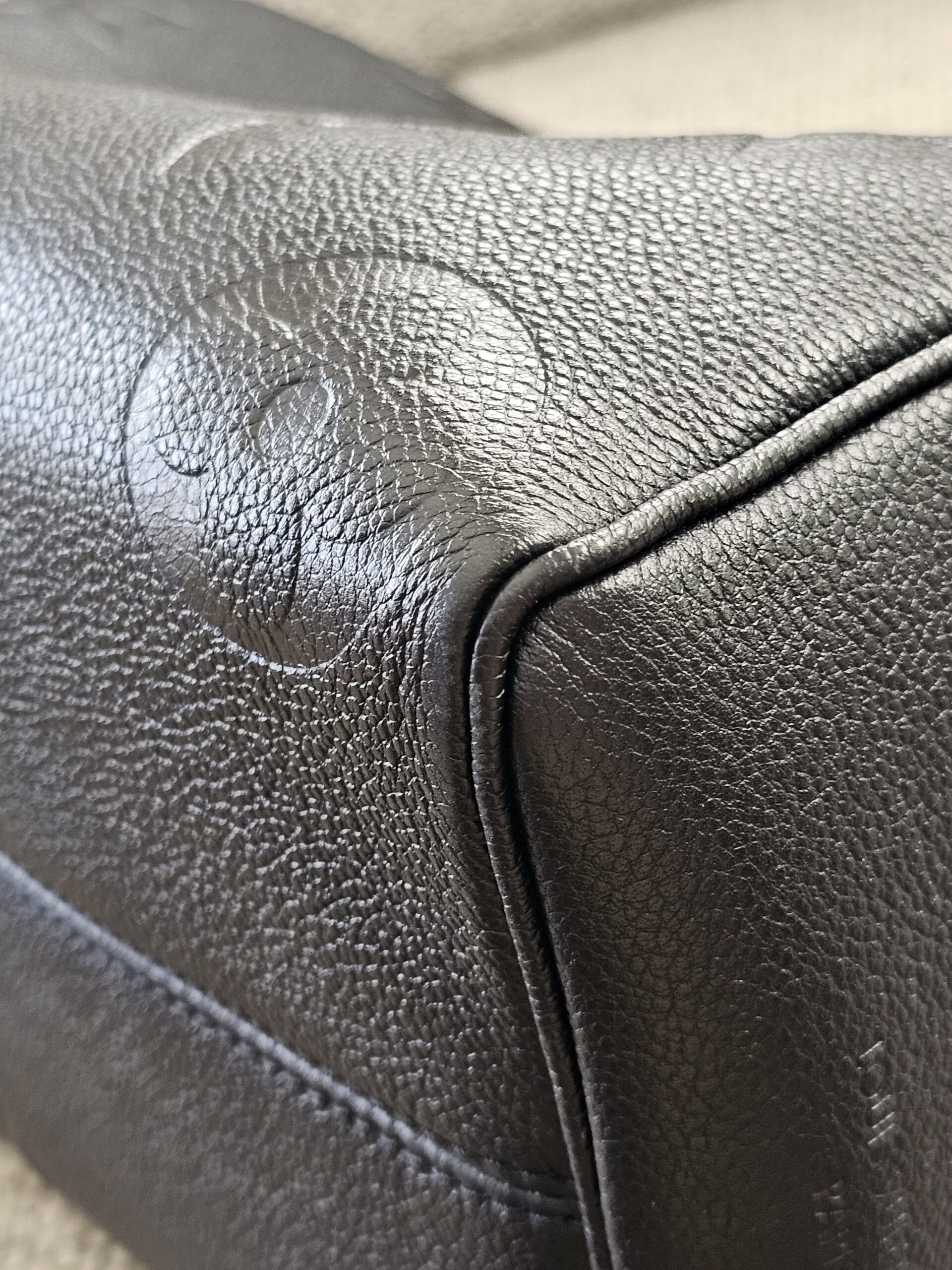 Close-up of a corner on the black Empreinte Speedy Bandouliere 25 showing light edge wear