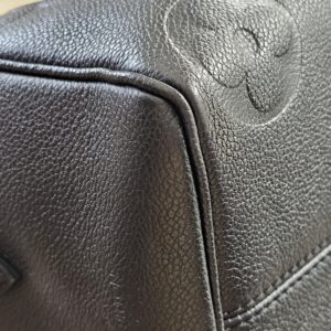 Embossed monogram flower at the corner of the black Empreinte Speedy Bandouliere 25
