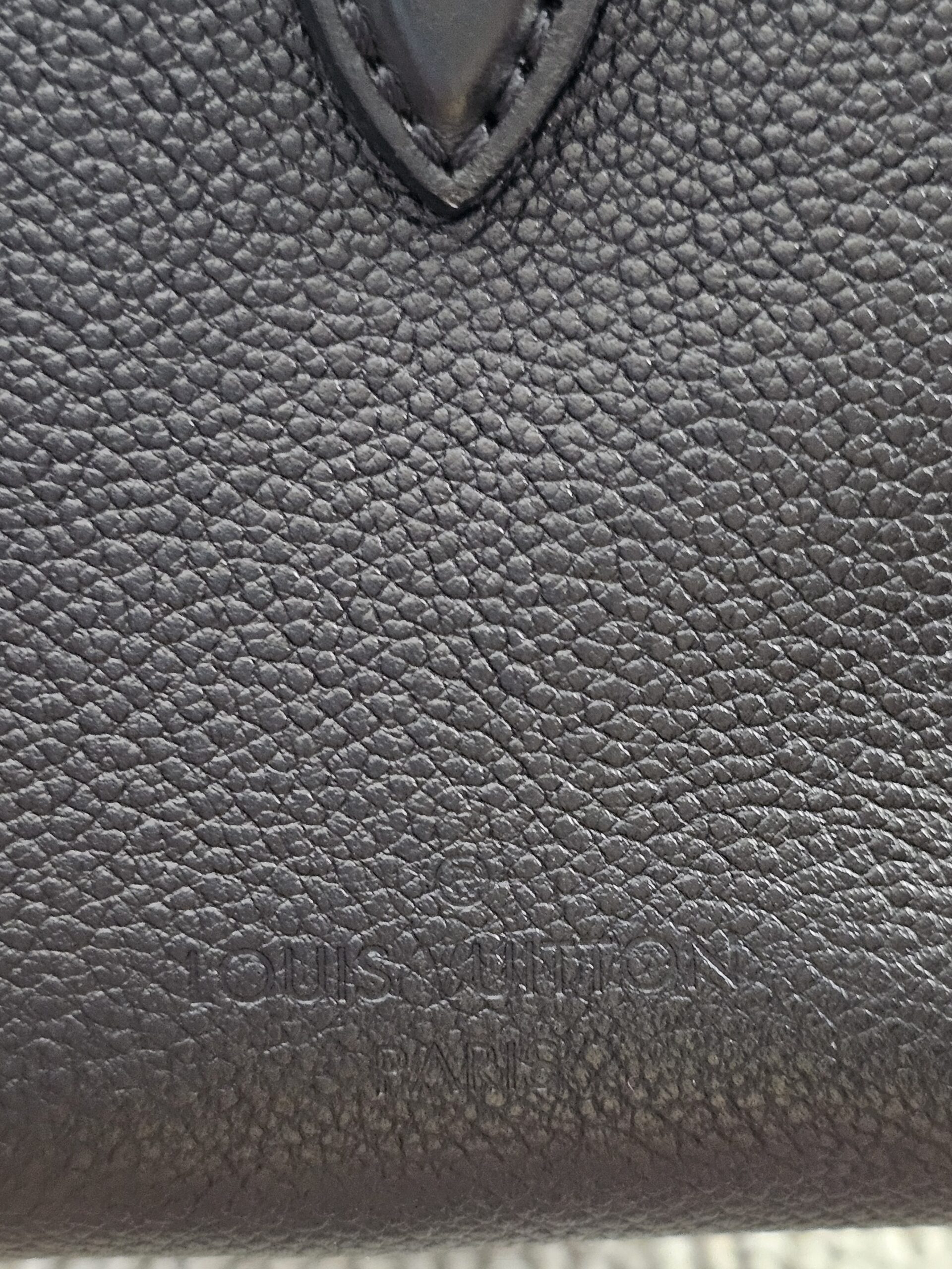 LOUIS VUITTON lettering embossed into the black Monogram Empreinte leather of the Speedy Bandouliere 25