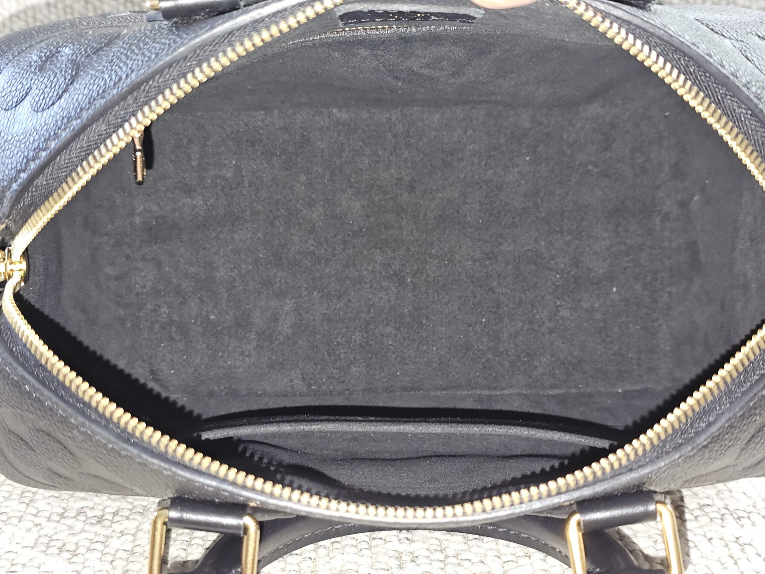 Black Empreinte Speedy Bandouliere 25 opened to show the gray microfiber interior