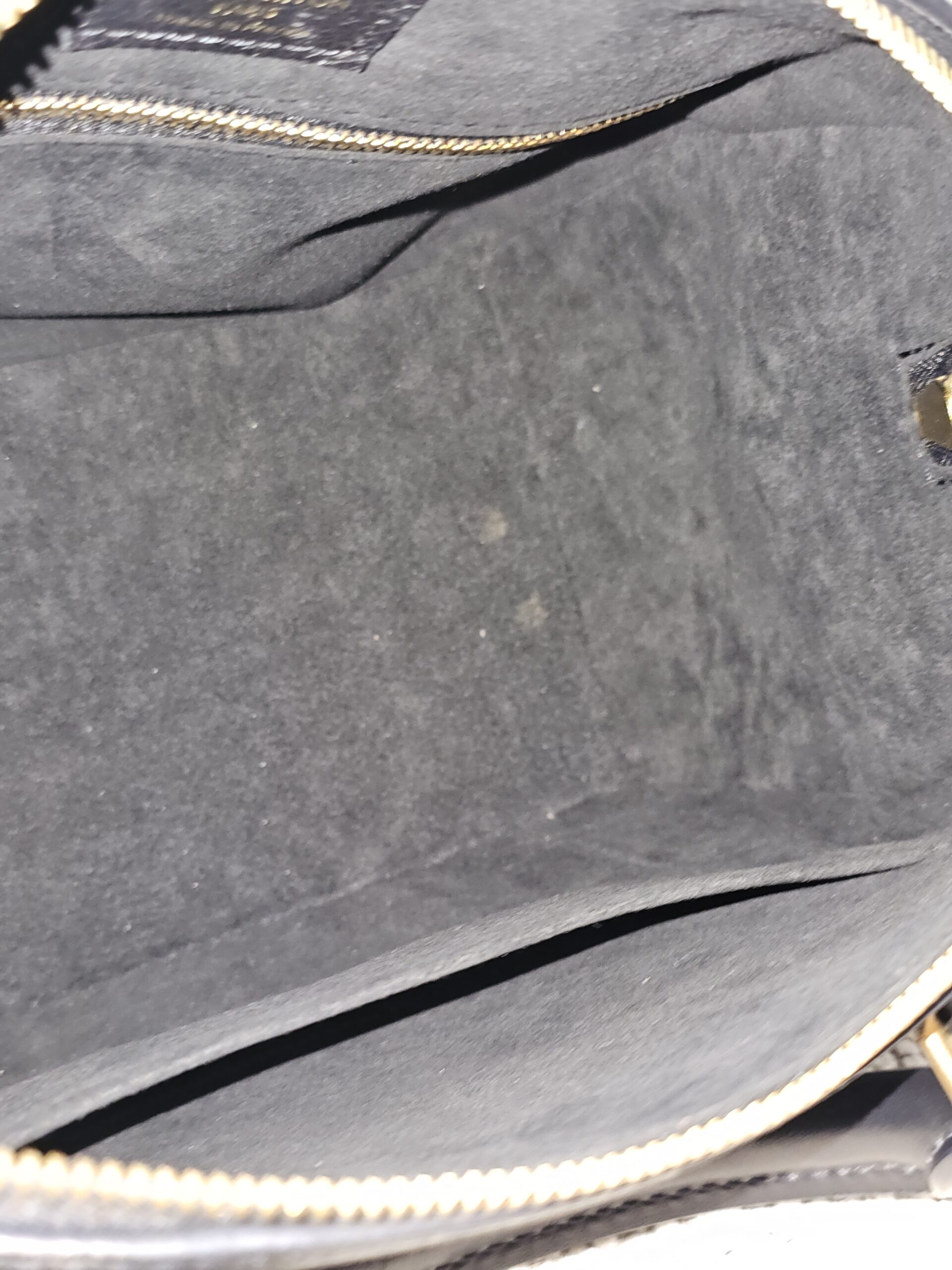 Interior pockets in the gray microfiber lining of the black Empreinte Speedy Bandouliere 25