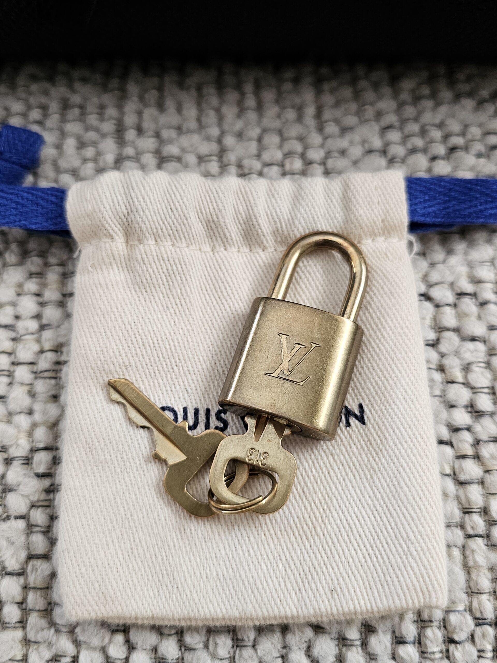 Louis Vuitton brass padlock and keys with their dust pouch, included with the Speedy Bandouliere 25