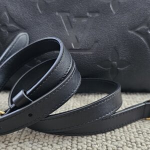 Black Empreinte Speedy Bandouliere 25 photographed with its leather shoulder strap coiled beside it