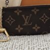 Louis Vuitton Monogram Key Pouch - front view with the gold-tone chain and hook, shown with its box