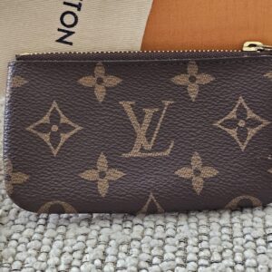 Reverse of the Monogram Key Pouch with its retail tag and box