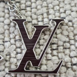 Close-up of the plum Epi LV initials motif on the Louis Vuitton Fleur de Epi bag charm