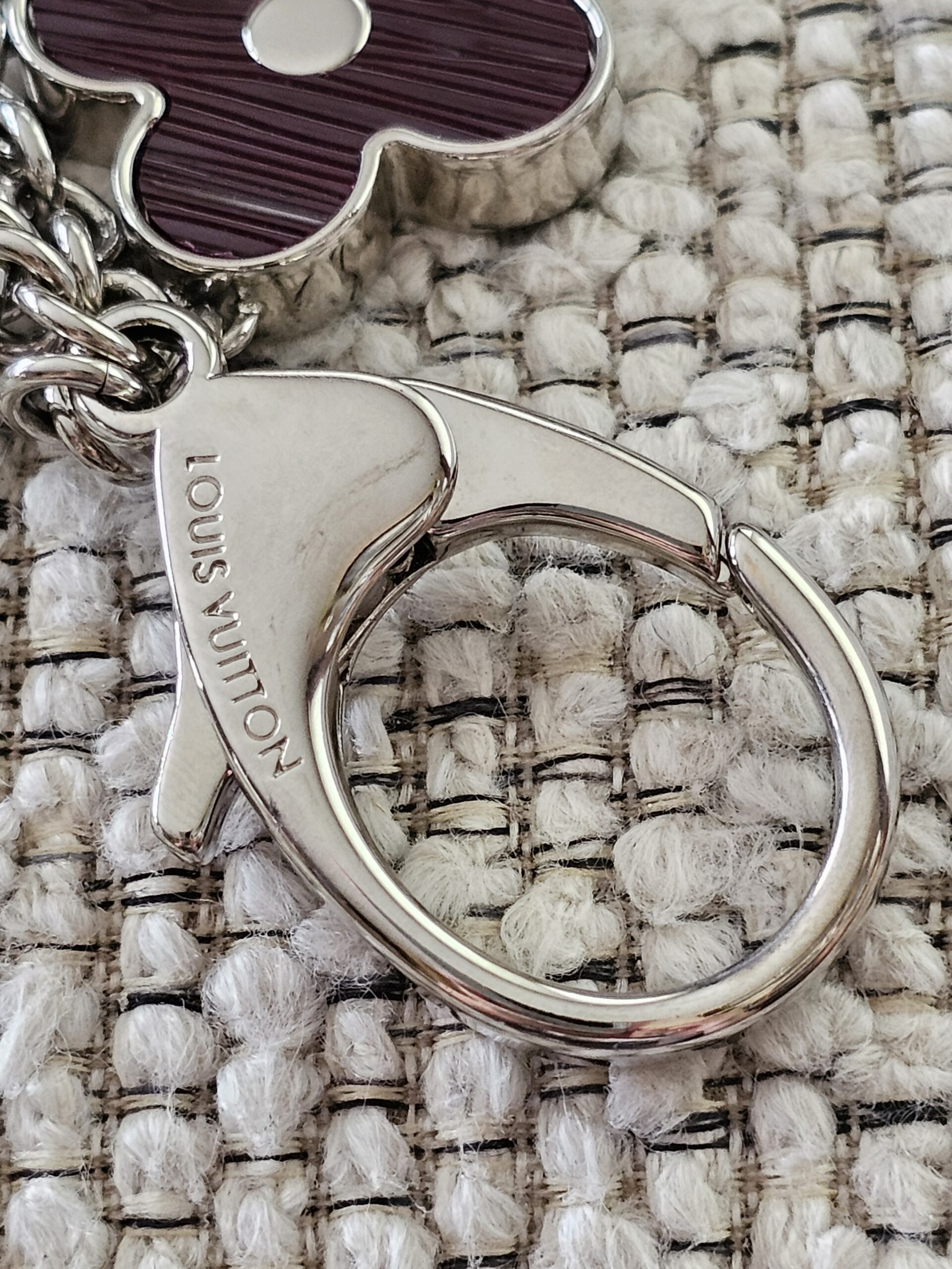 LOUIS VUITTON engraved on the silver-tone lobster clasp of the Fleur de Epi bag charm