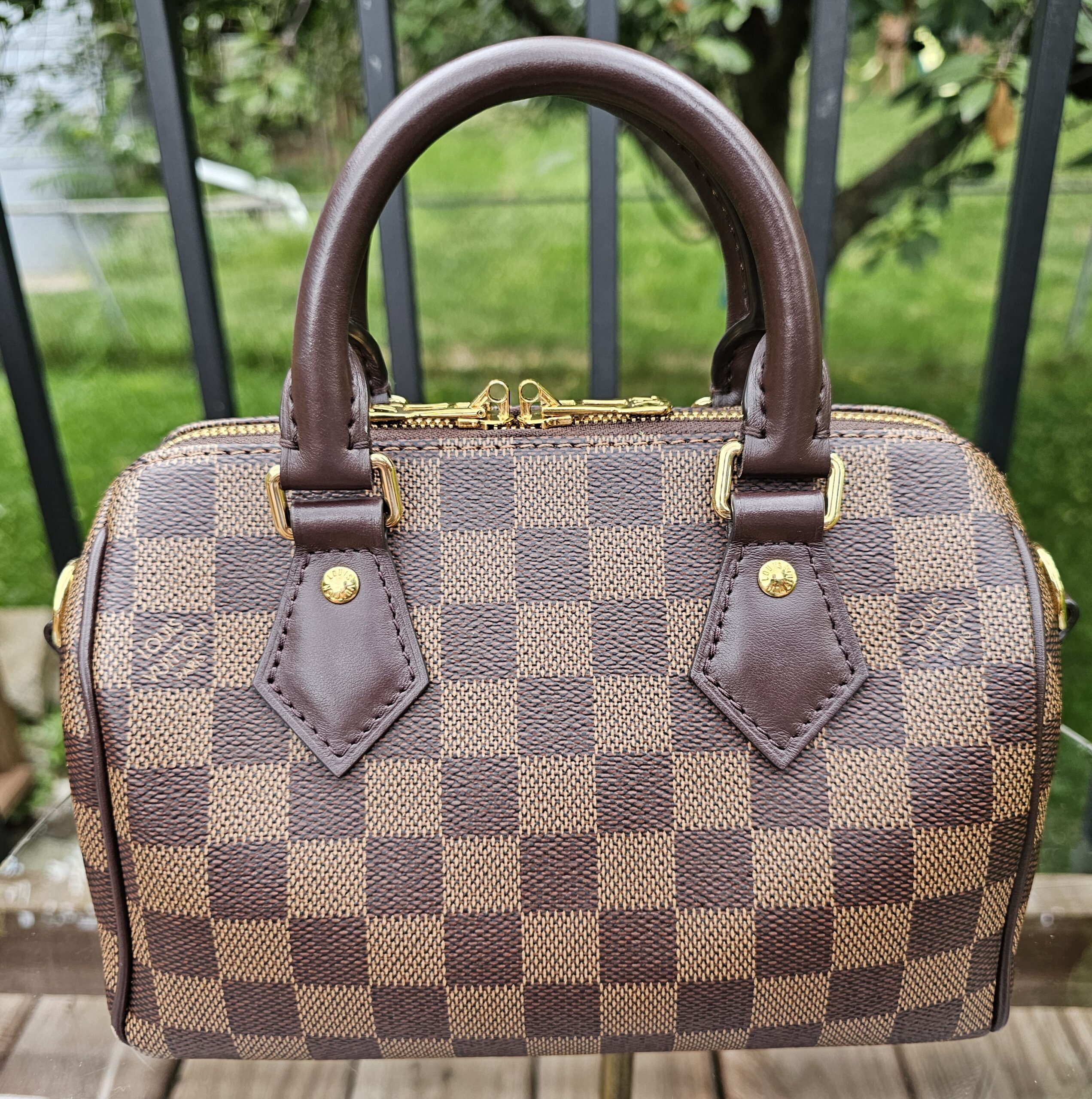 Front view of the Louis Vuitton Damier Ebene Speedy Bandouliere 20 with rolled leather handles