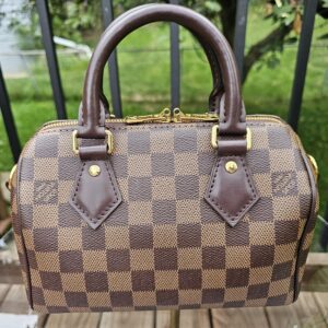 Angled front view of the Damier Ebene Speedy Bandouliere 20 showing the checkerboard canvas