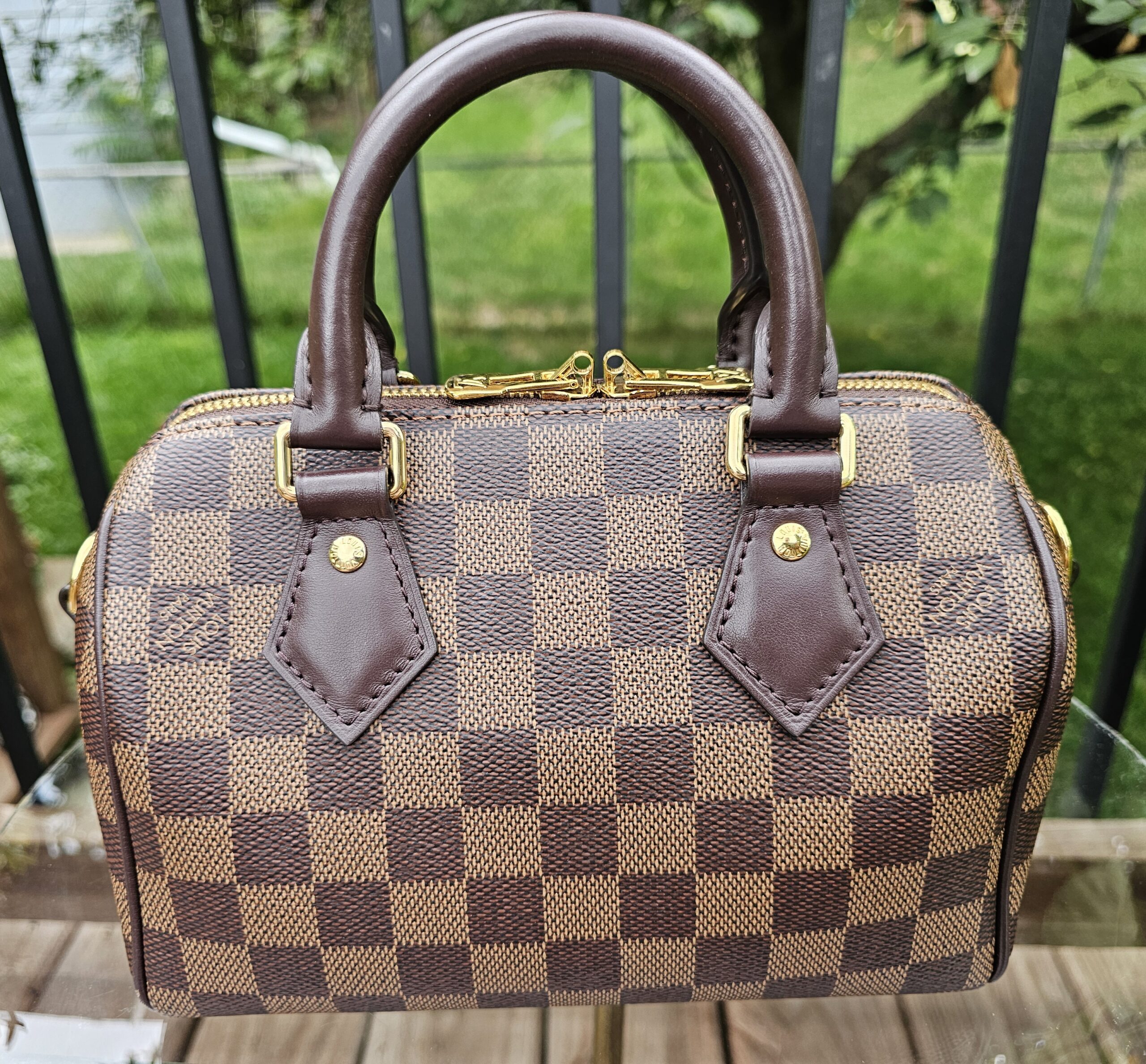 Angled front view of the Damier Ebene Speedy Bandouliere 20 showing the checkerboard canvas