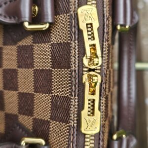 Close-up of the gold-tone zipper and pulls on the Damier Ebene Speedy Bandouliere 20