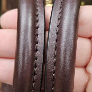 Rolled leather handles of the Speedy Bandouliere 20 held together to show their condition