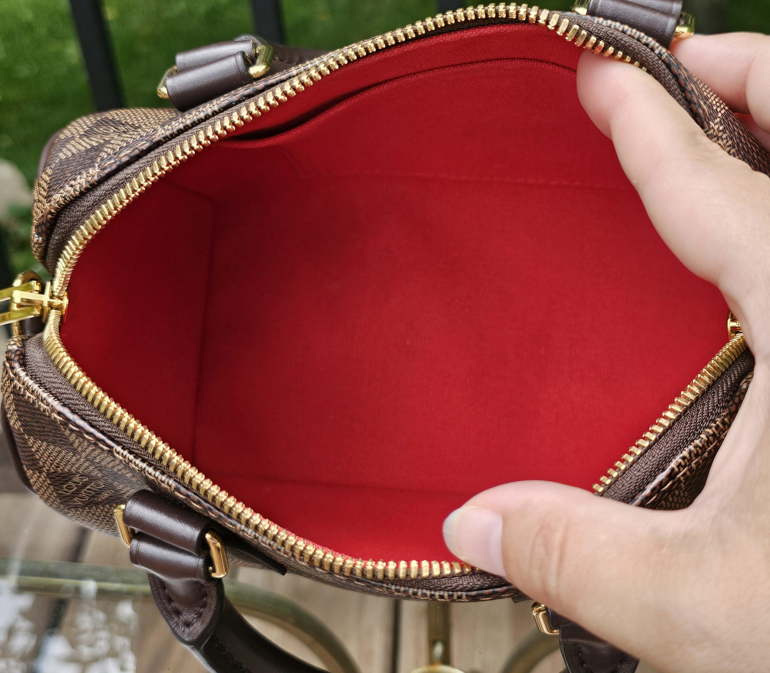 Speedy Bandouliere 20 held open to show the red fabric interior
