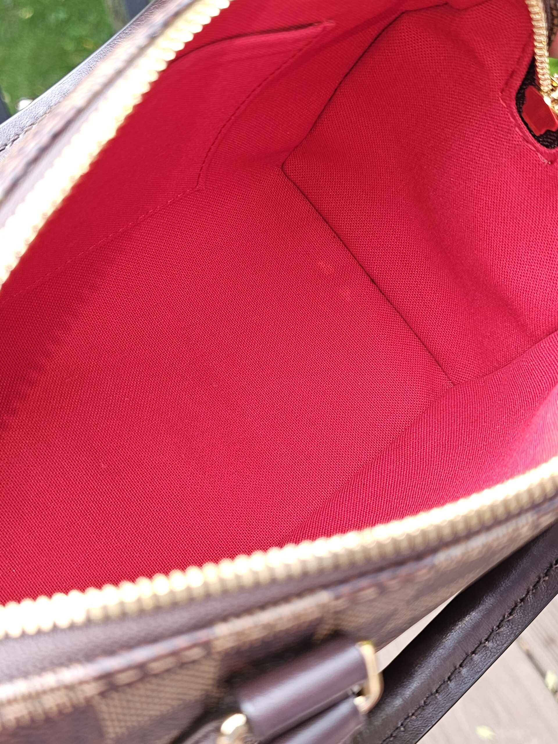 Red interior lining and gold-tone zipper track of the Speedy Bandouliere 20