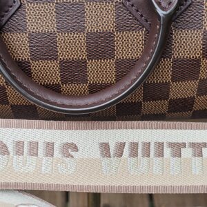 LOUIS VUITTON lettering woven into the beige jacquard shoulder strap
