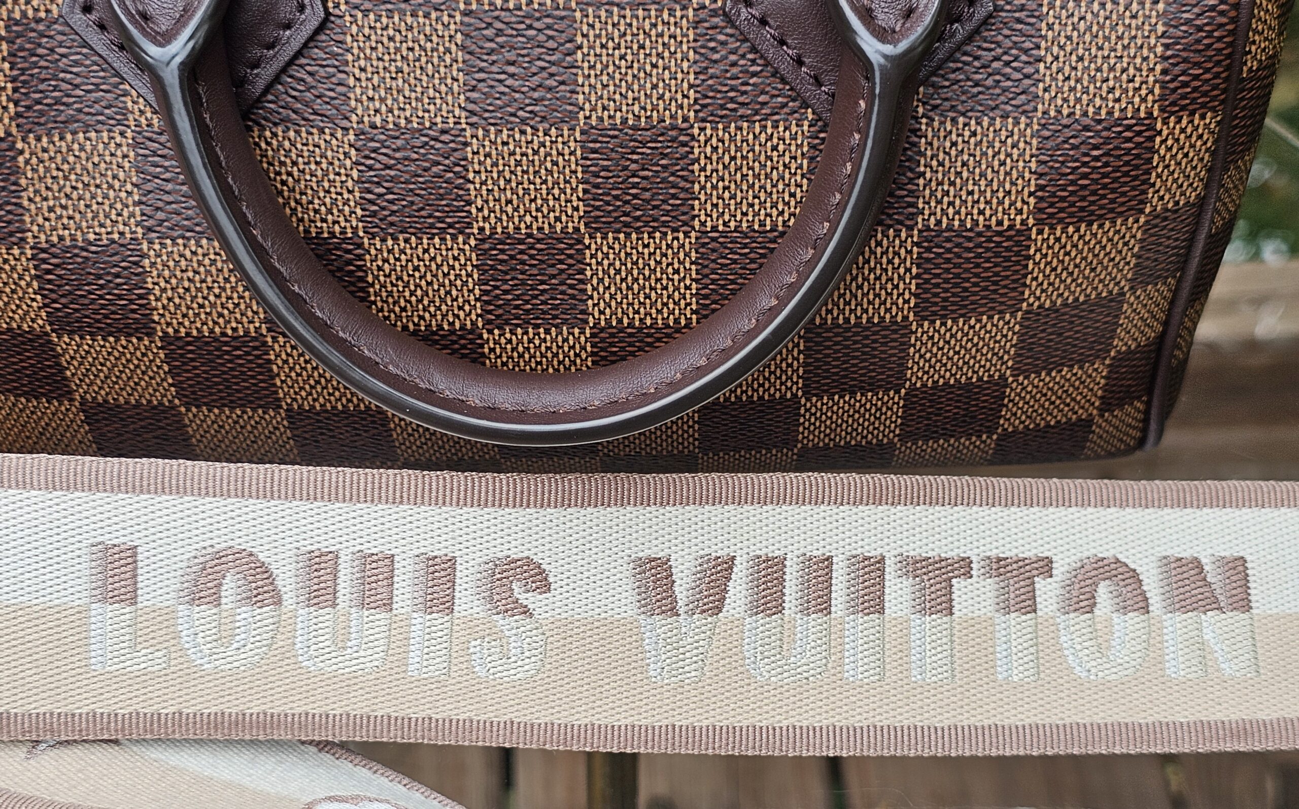 LOUIS VUITTON lettering woven into the beige jacquard shoulder strap