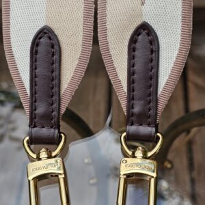 Gold-tone snap hooks at both ends of the Louis Vuitton jacquard shoulder strap