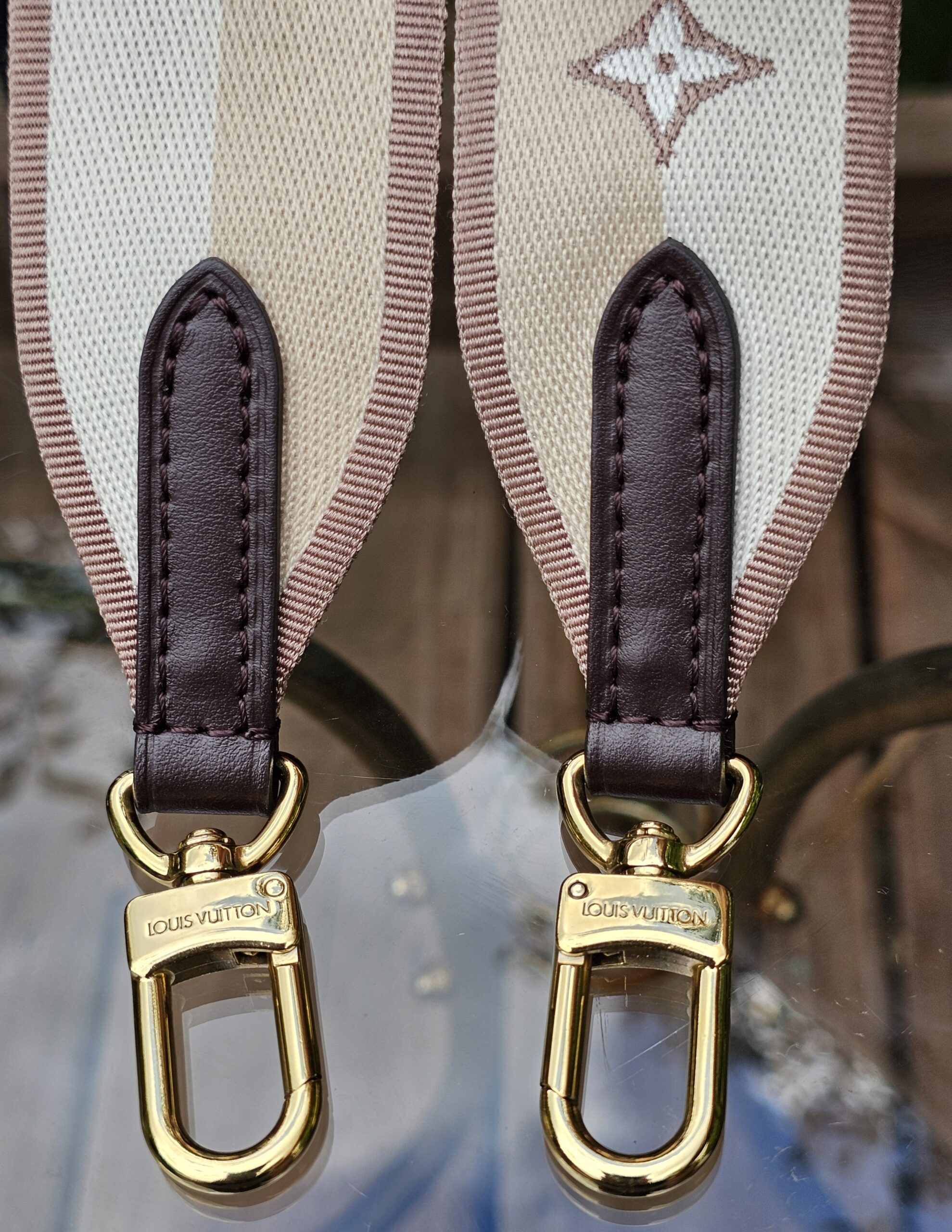 Gold-tone snap hooks at both ends of the Louis Vuitton jacquard shoulder strap