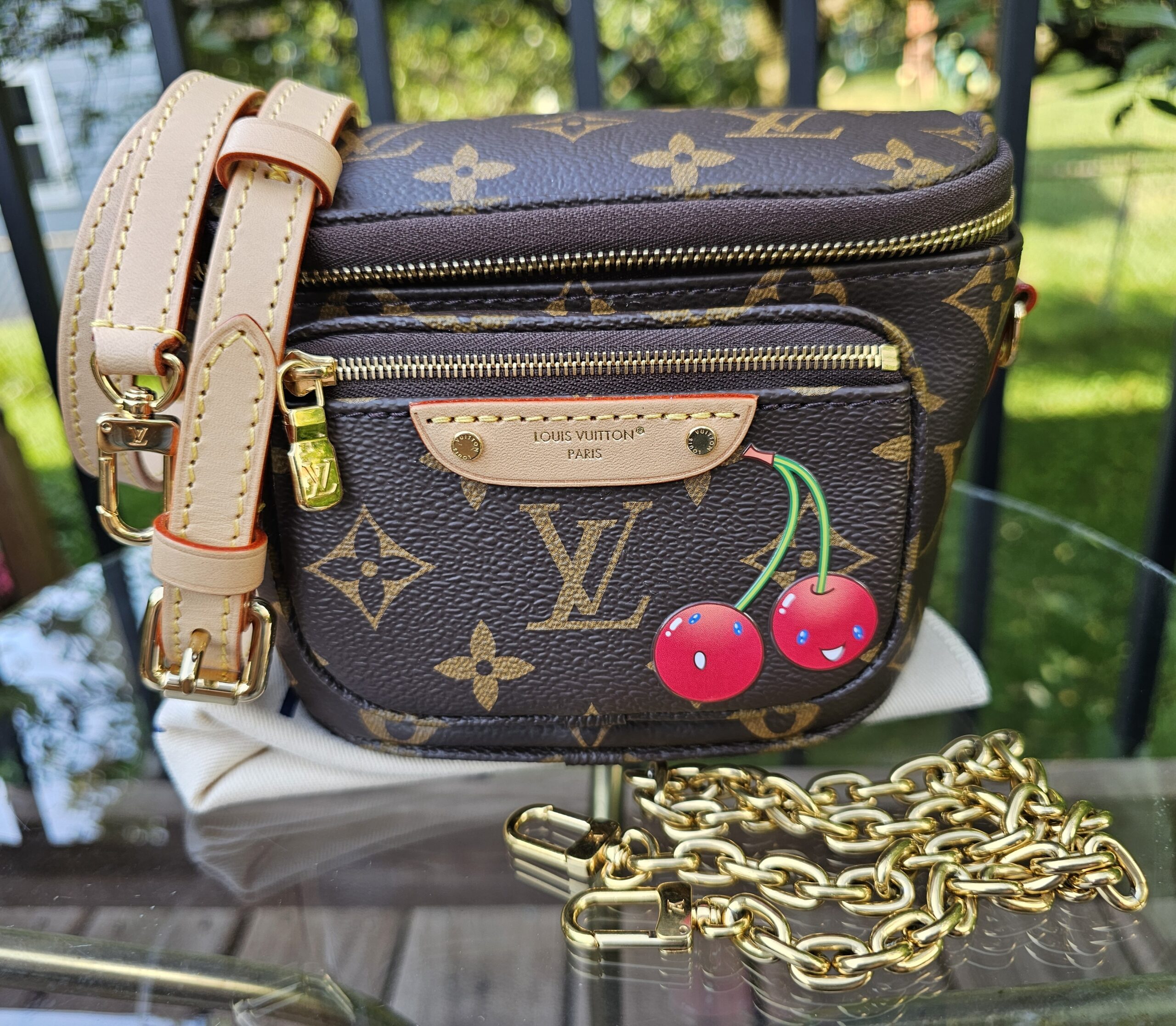 Louis Vuitton x Takashi Murakami Monogram Cerises Mini Bumbag shown with its leather strap and gold-tone chain