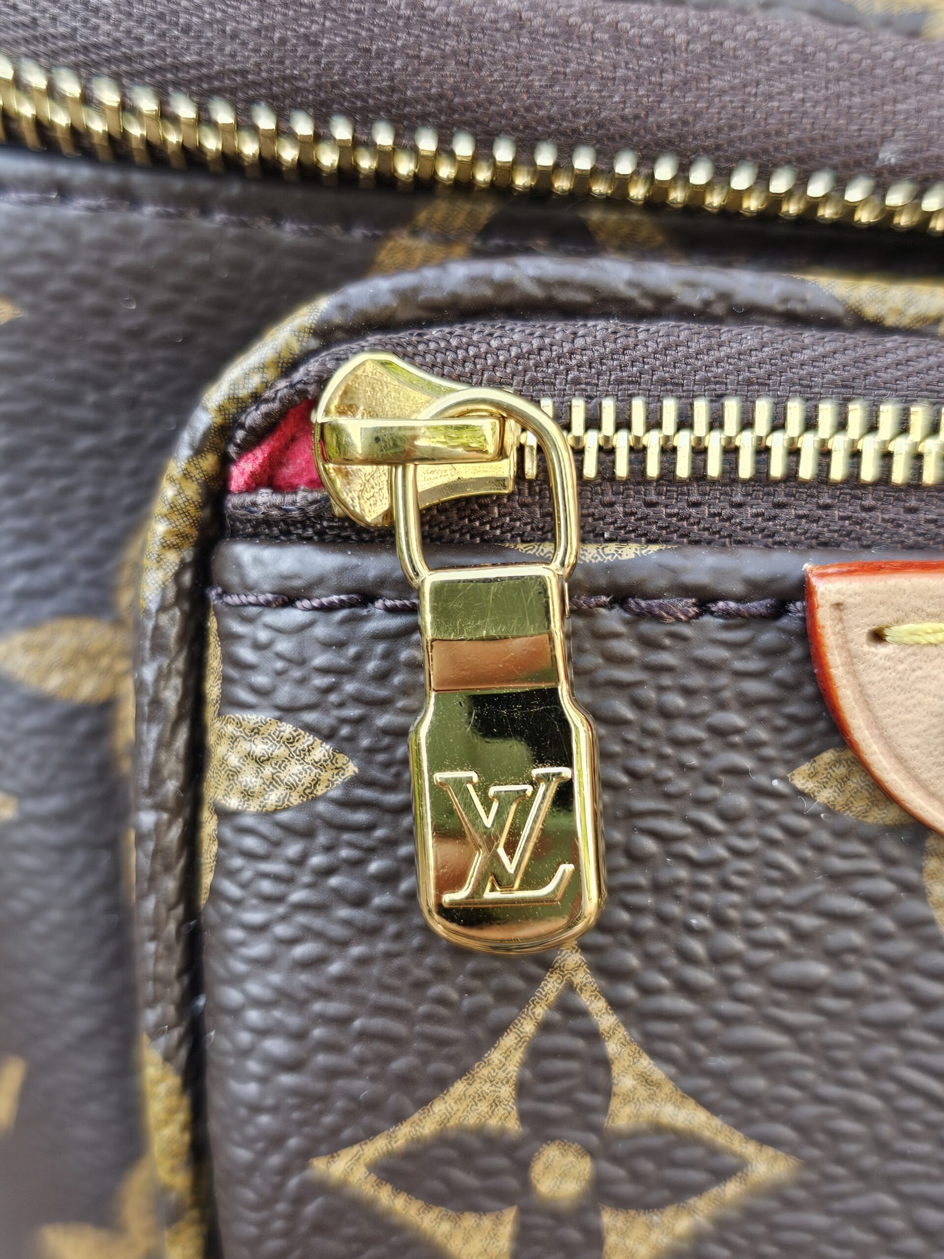 Gold-tone LV zip pull on the Monogram Cerises Mini Bumbag