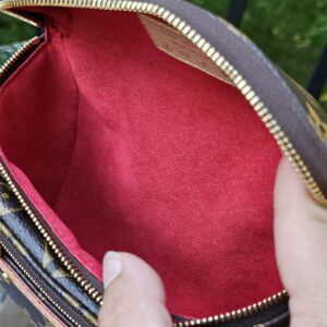 Cerises Mini Bumbag held open to show the red microfiber lining