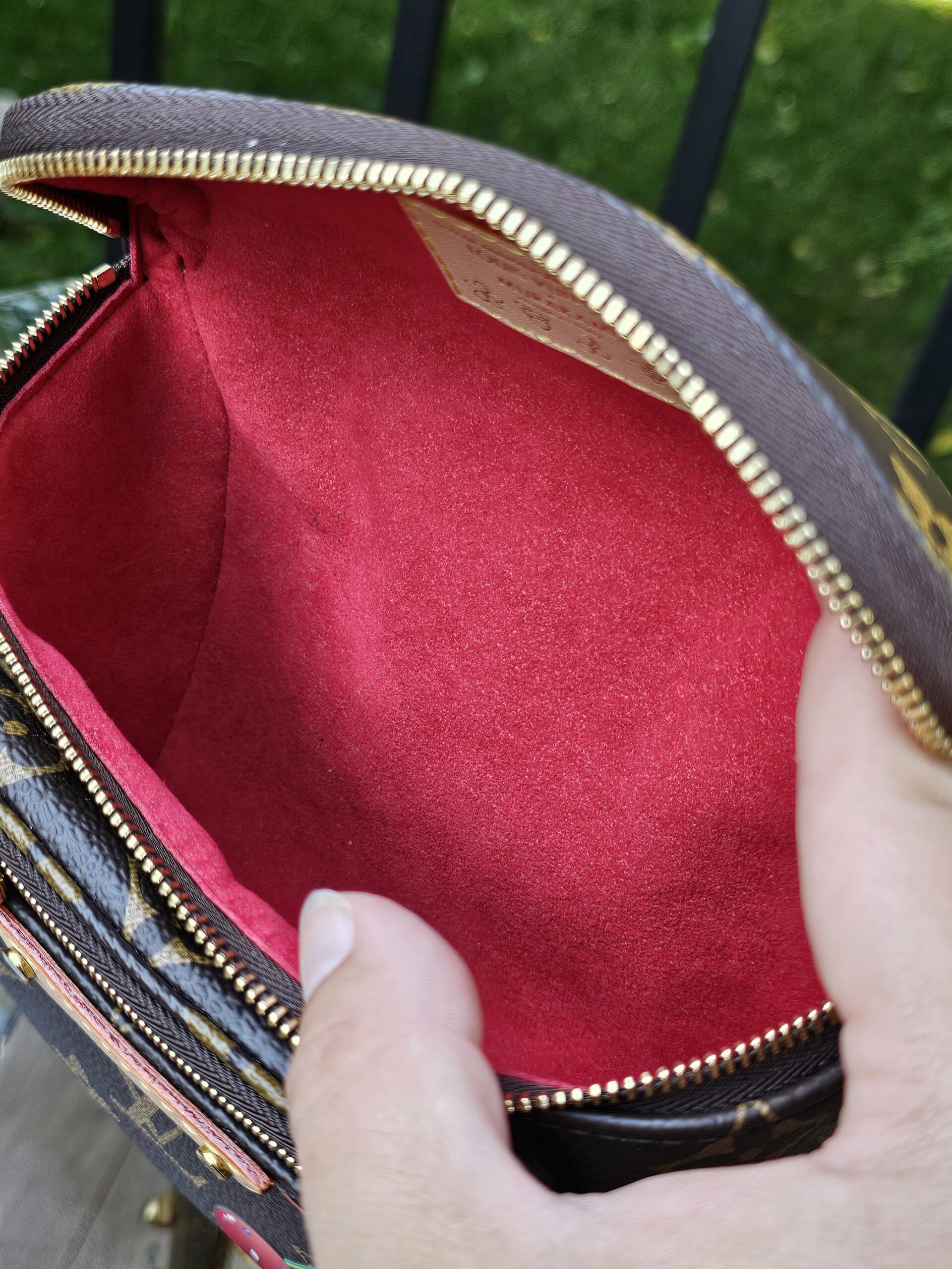 Cerises Mini Bumbag held open to show the red microfiber lining