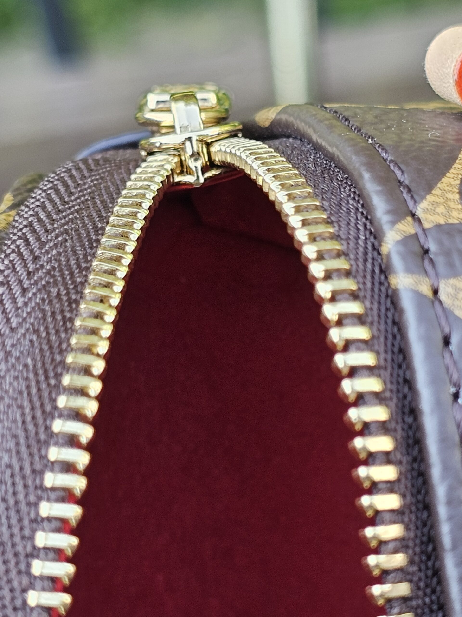 Zip opening of the Monogram Cerises Mini Bumbag with the red lining visible