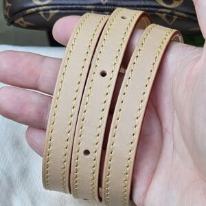 Adjustable vachetta leather strap for the Cerises Mini Bumbag held in hand