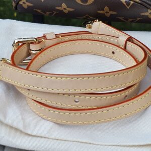 Vachetta leather strap for the Cerises Mini Bumbag coiled on its dust bag