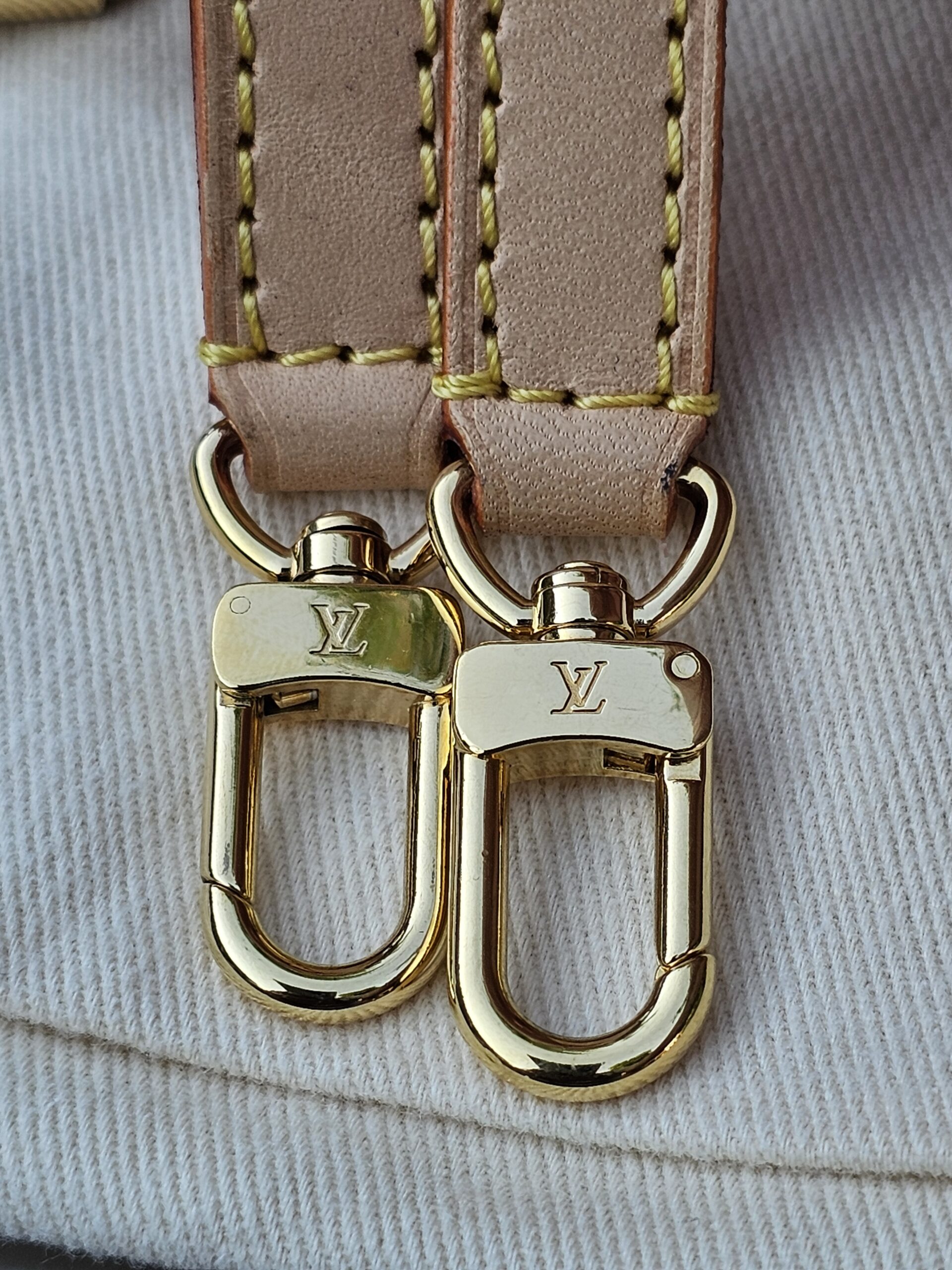 Gold-tone LV snap hooks on the vachetta leather strap of the Cerises Mini Bumbag