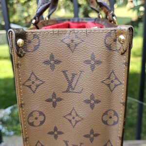 Side panel of the Reverse Monogram Giant OnTheGo PM in dark monogram canvas