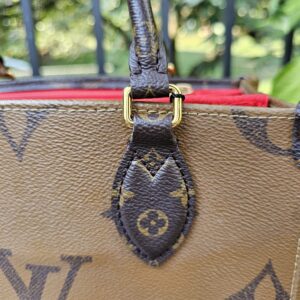 Second handle attachment on the Reverse Monogram Giant OnTheGo PM showing edge wear