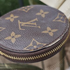 Monogram round pouch angled to show the zip-around closure