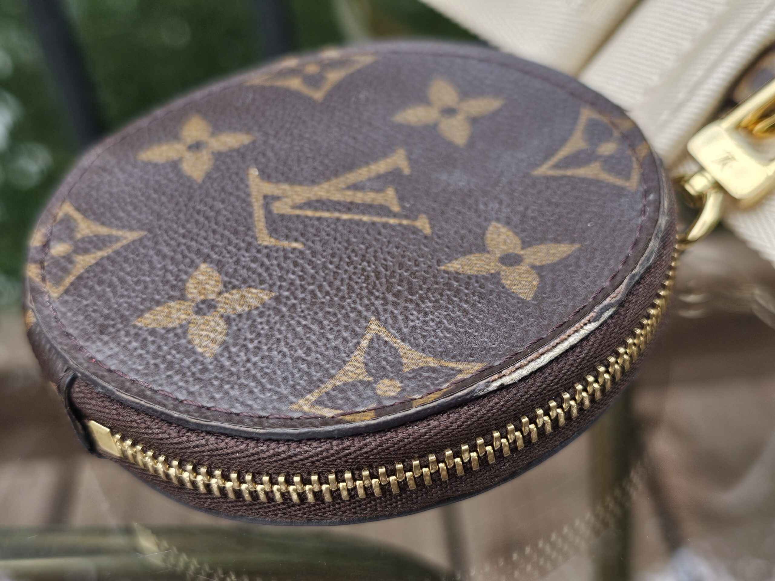 Monogram round pouch angled to show the zip-around closure