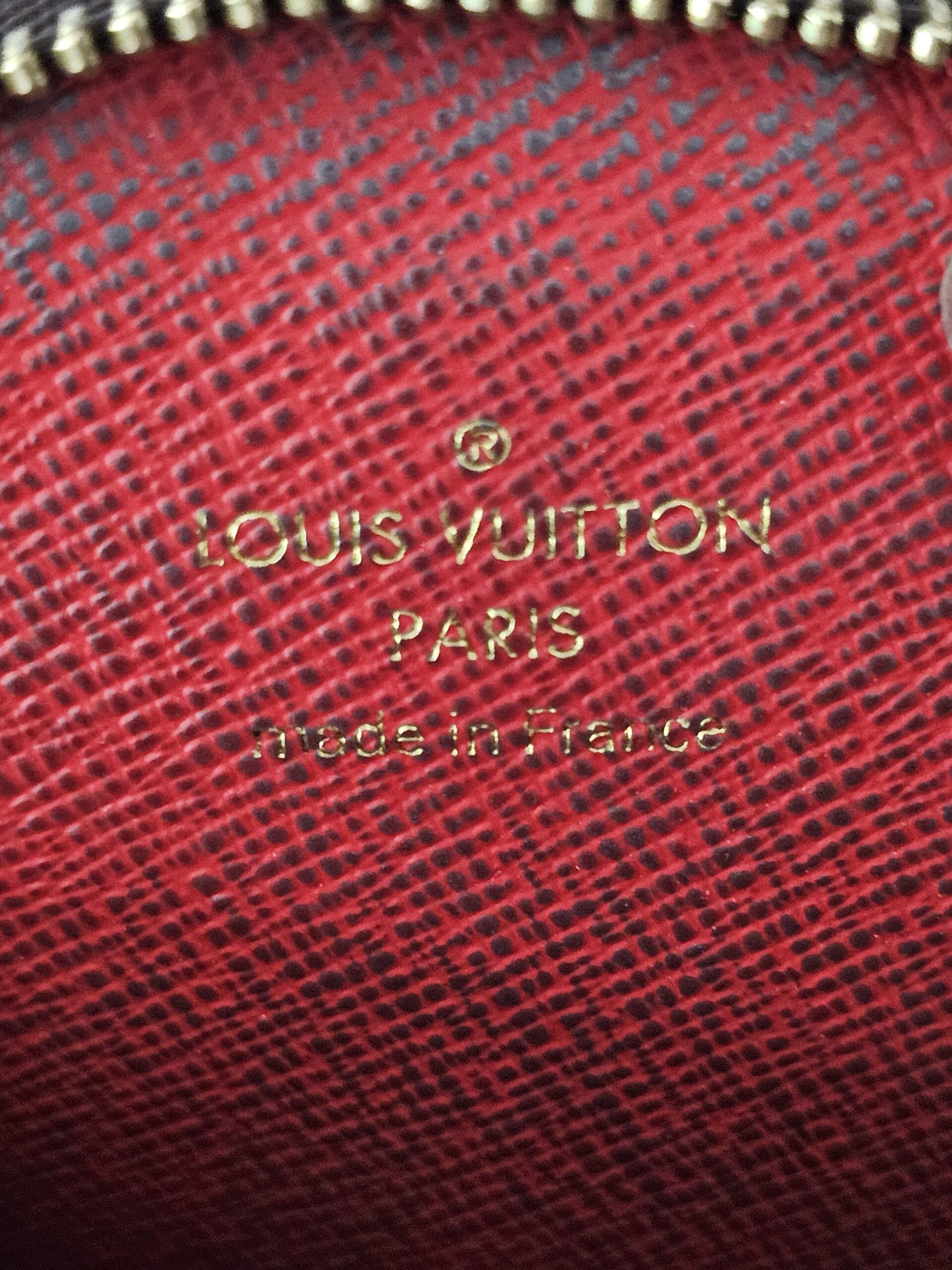 LOUIS VUITTON PARIS made in France stamp inside the red lining of the round pouch