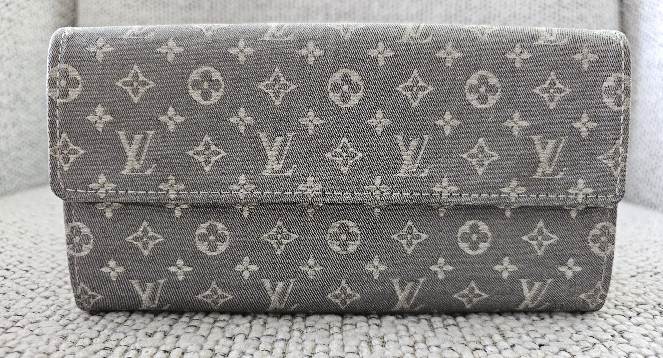 Louis Vuitton Monogram Mini Lin Sarah Wallet Gray - closed front view showing the woven gray monogram textile