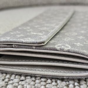 Side profile of the gray Monogram Mini Lin Sarah Wallet showing the folded card compartments