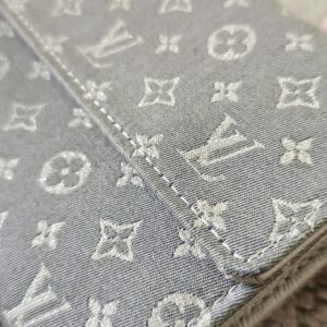 Close-up of the gray Monogram Mini Lin woven textile on the Sarah Wallet