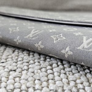 Closed profile of the gray Monogram Mini Lin Sarah Wallet showing the snap flap