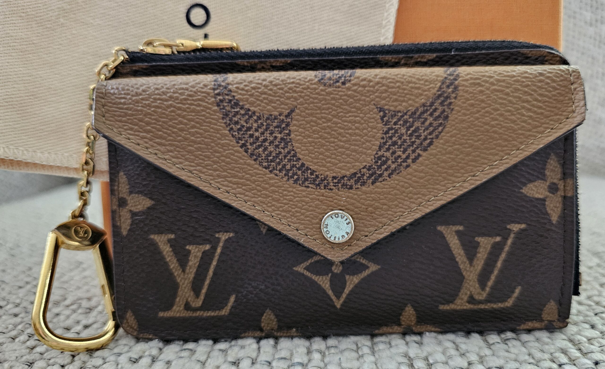 Louis Vuitton Reverse Monogram Recto Verso Card Holder - front view with the envelope snap pocket and gold-tone hook