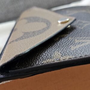 Angled view of the Monogram Reverse Recto Verso card holder with its dust bag