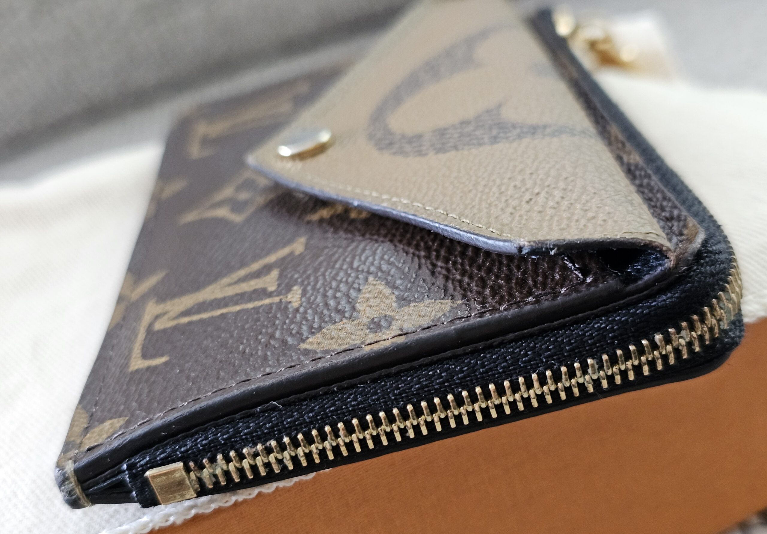 Zippered compartment and gold-tone zip on the Reverse Monogram Recto Verso card holder