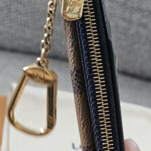 Reverse Monogram Recto Verso card holder held in hand showing its compact size and chain