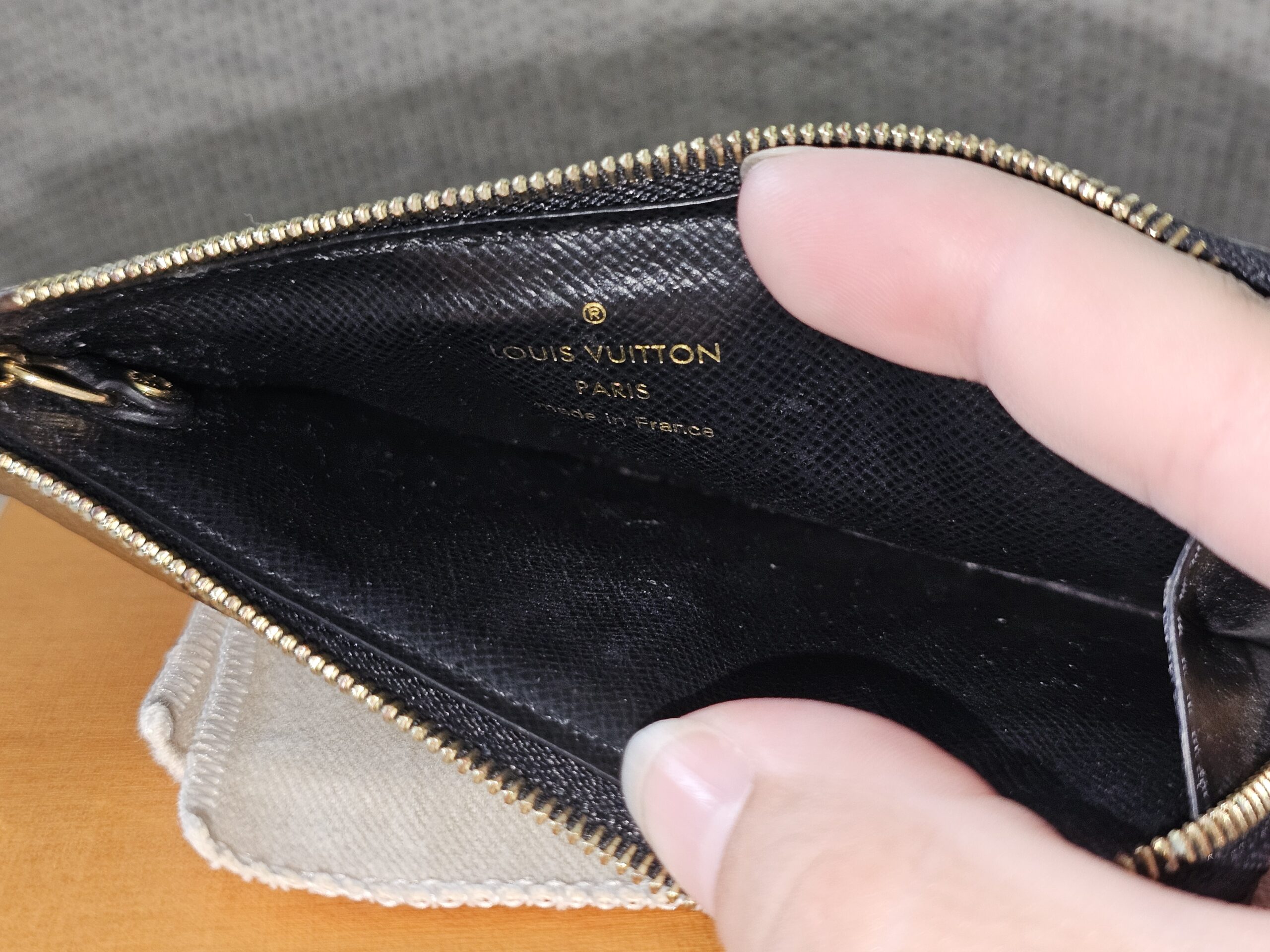 Recto Verso card holder opened to show the black leather interior and Louis Vuitton Paris stamp