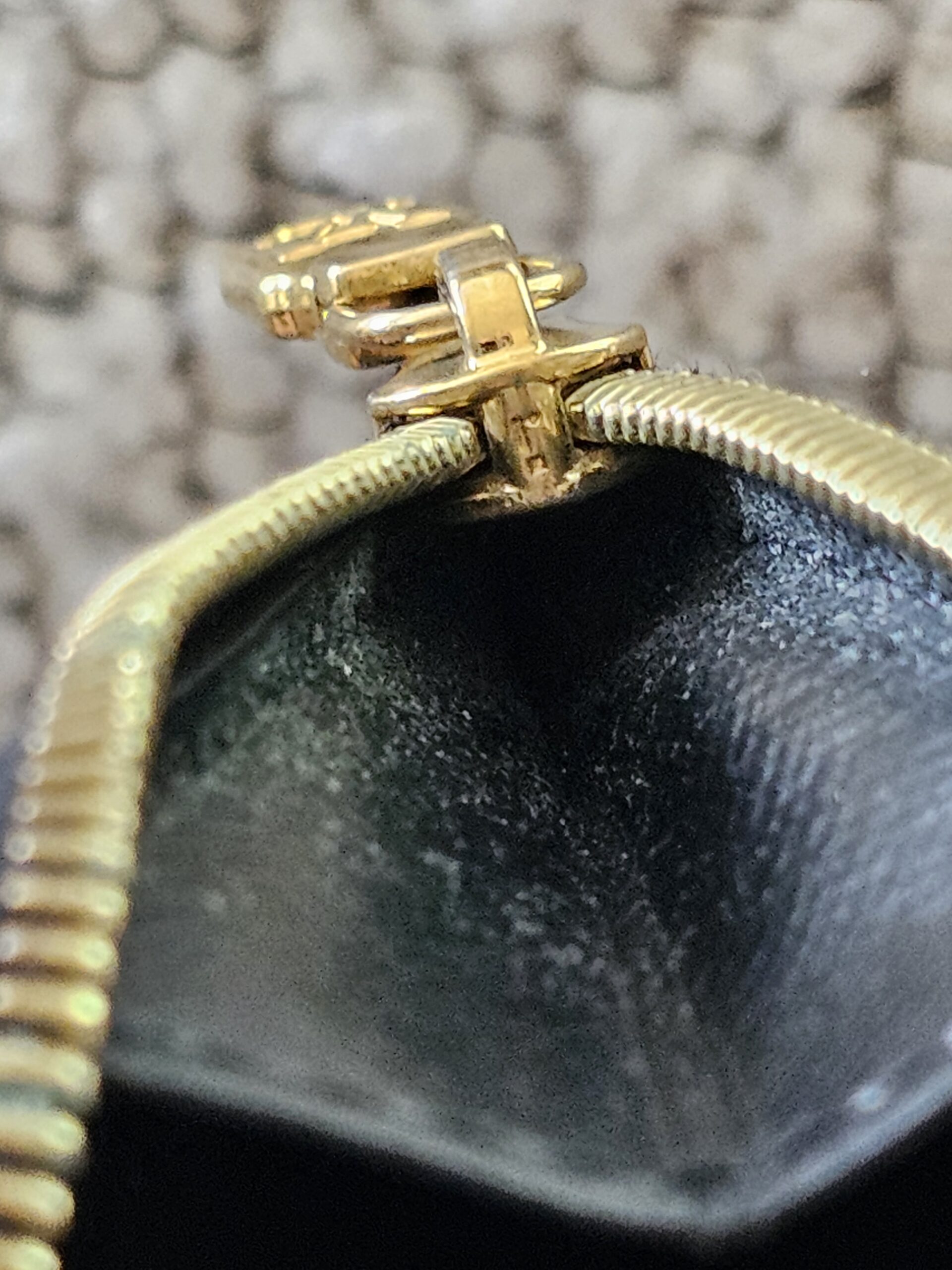 Close-up of the gold-tone zipper pull on the Reverse Monogram Recto Verso card holder